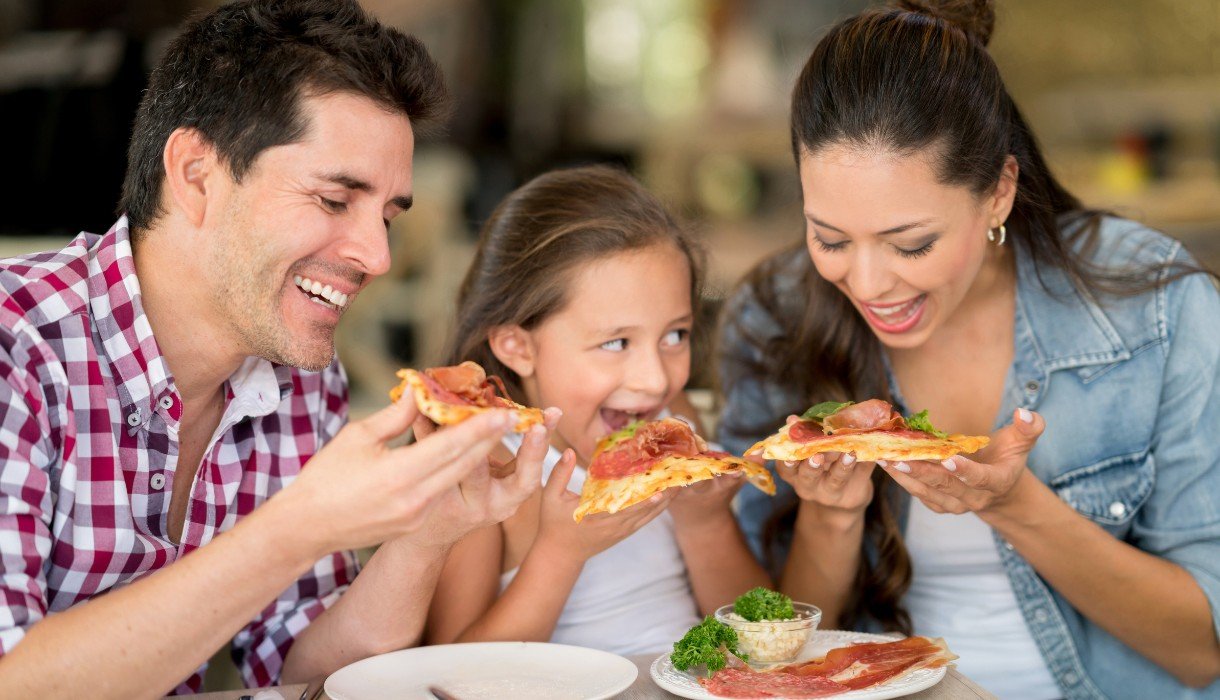 Family eating pizza at a restaurant_ in York, Maine- Image by andresr from Getty Images Signature