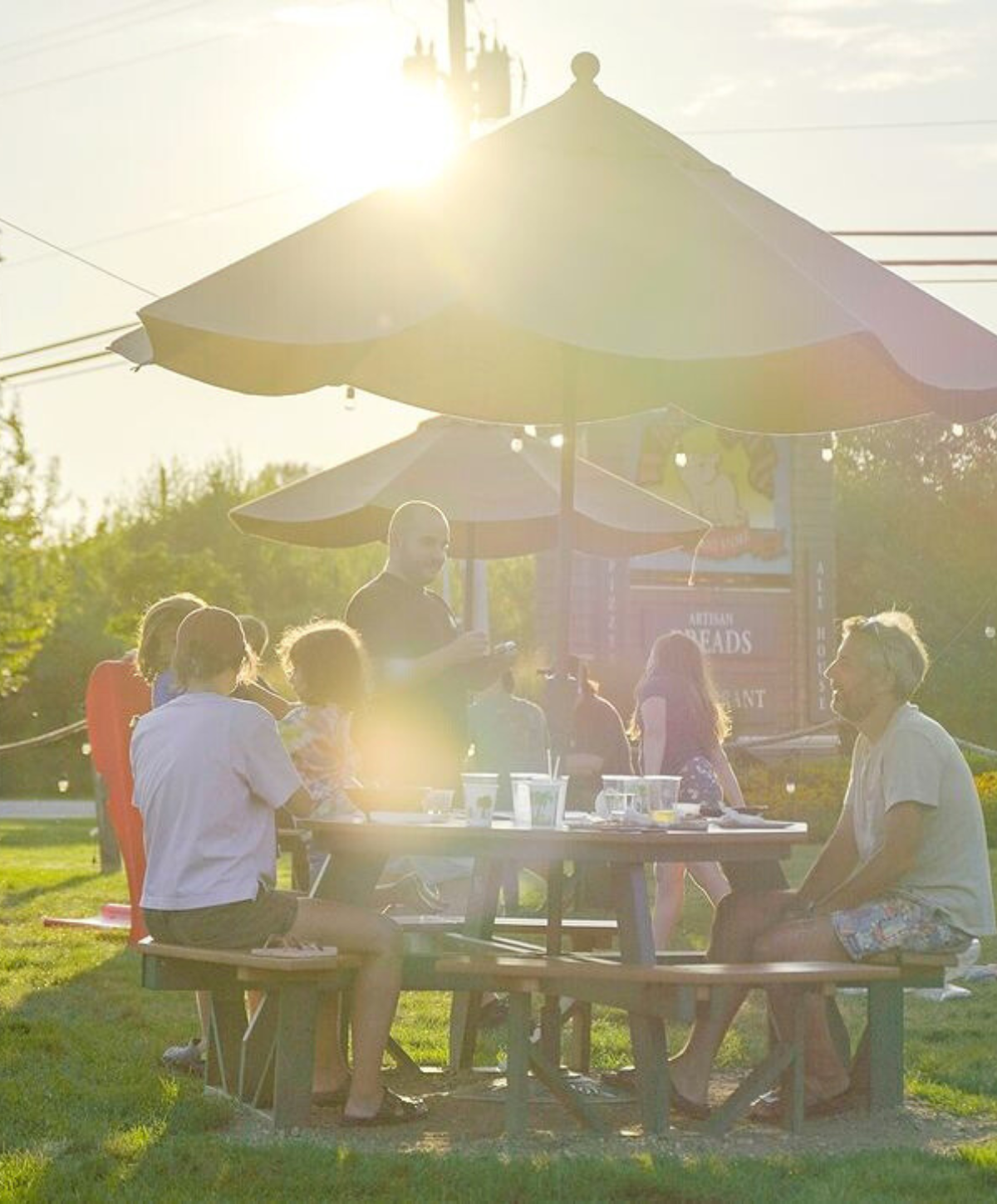 People seating outside in the lawn at When Pigs Fly Restaurant Pizzeria Restaurant in Kittery Maine